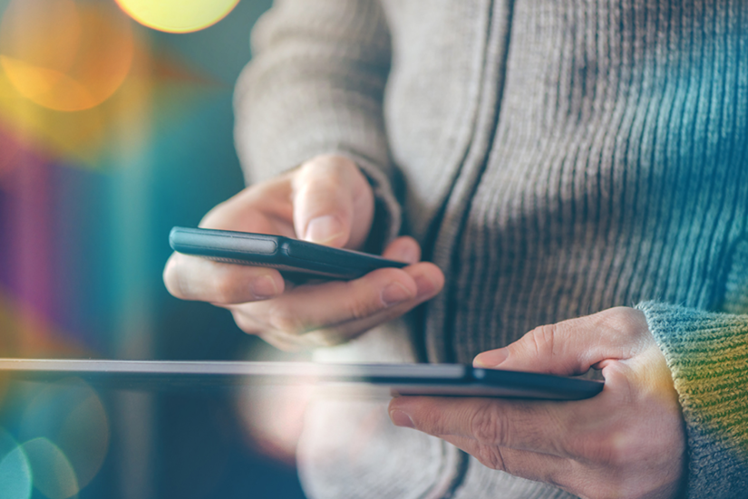 man holding a tablet and phone